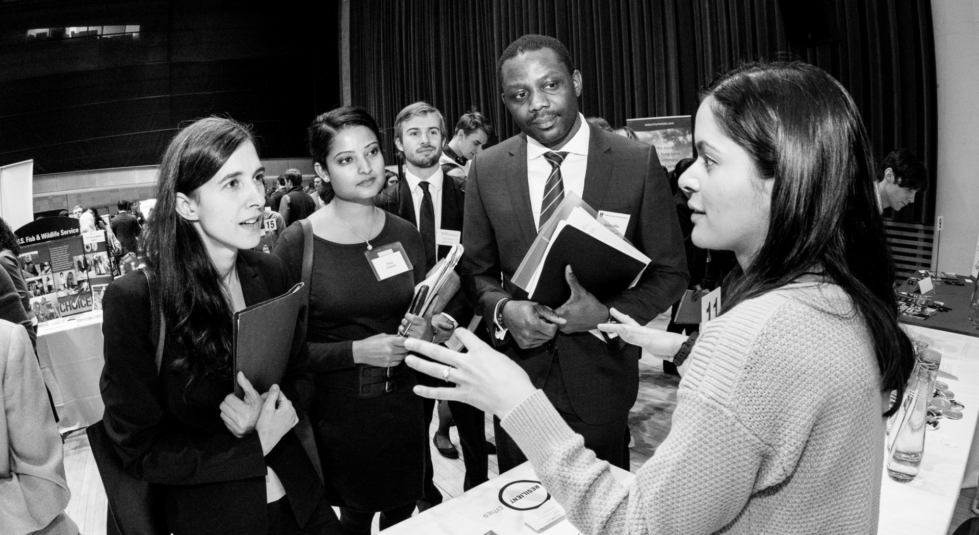 black and white photo of students speaking with a recruiter